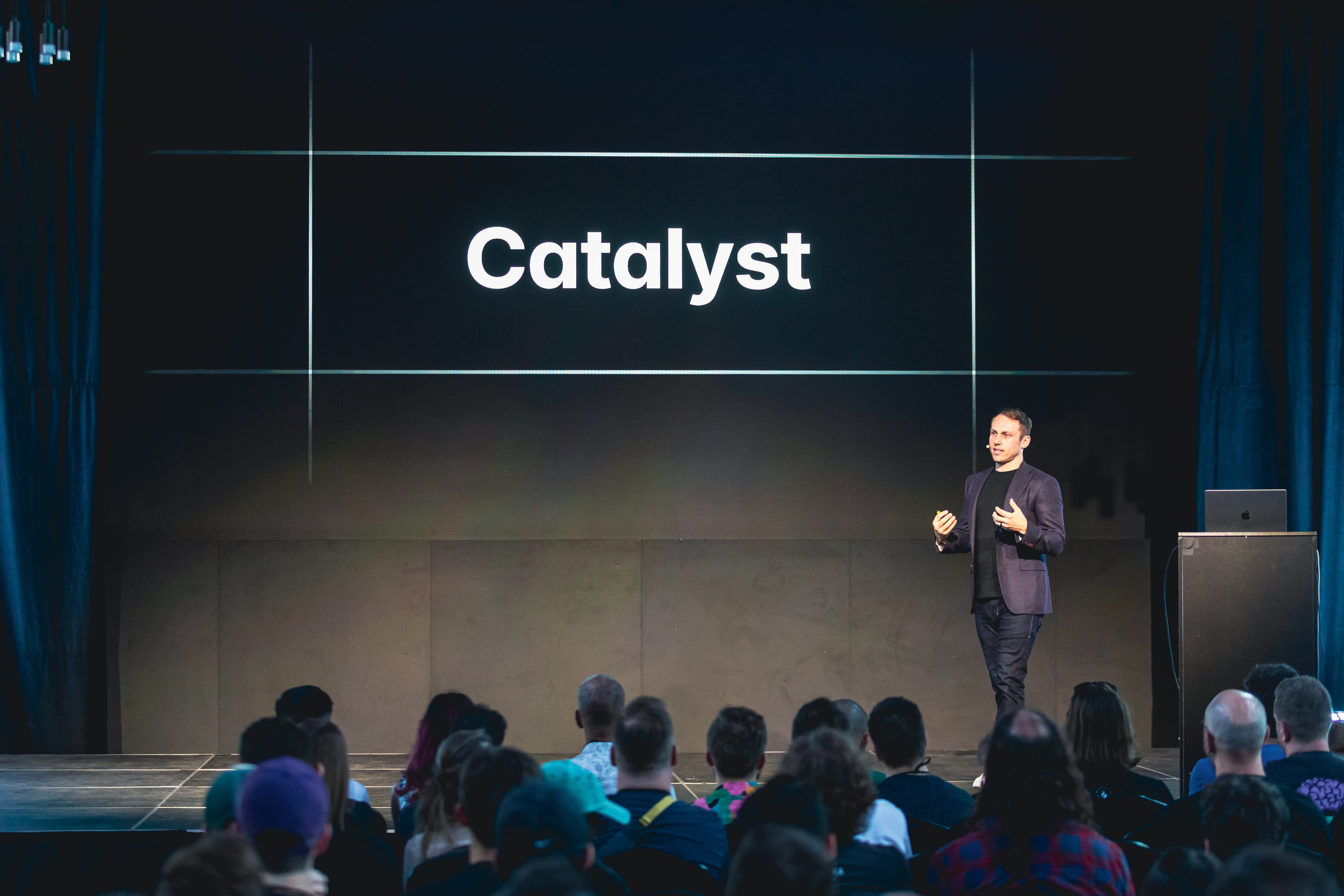 Adam Wathan en el escenario frente a una diapositiva que dice Catalyst
